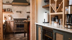 Een keuken met een centraal eiland, houten kasten en een wijnrek.