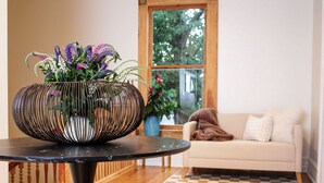 Een moderne woonkamer met een ronde zwarte tafel, een witte bank en een houten vloer.