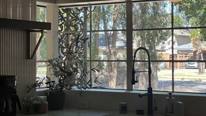A kitchen with a large window, a sink, and a coffee maker. - Spacious 6-bedroom house in marvelous Lubbock with AC, WiFi, fitness room (Lubbock)
