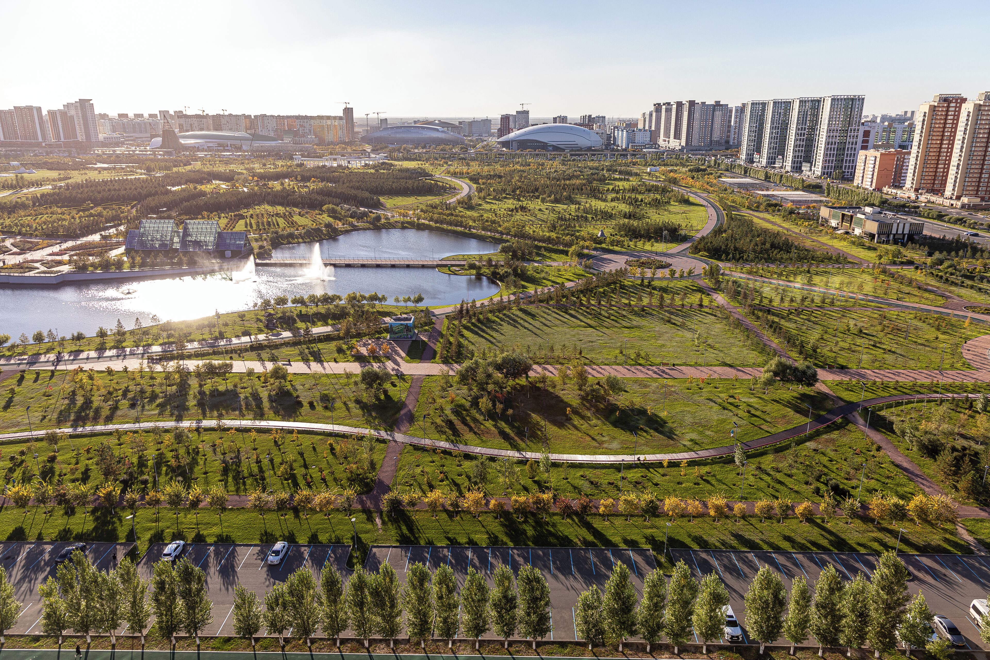 A large, modern urban area with green spaces, water bodies, and high-rise buildings.