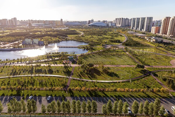 Un'ampia area urbana moderna con un fiume, aree verdi e grattacieli.