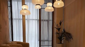 Een modern interieur met een bank, een potplant en een decoratieve wand met verticale lamellen.