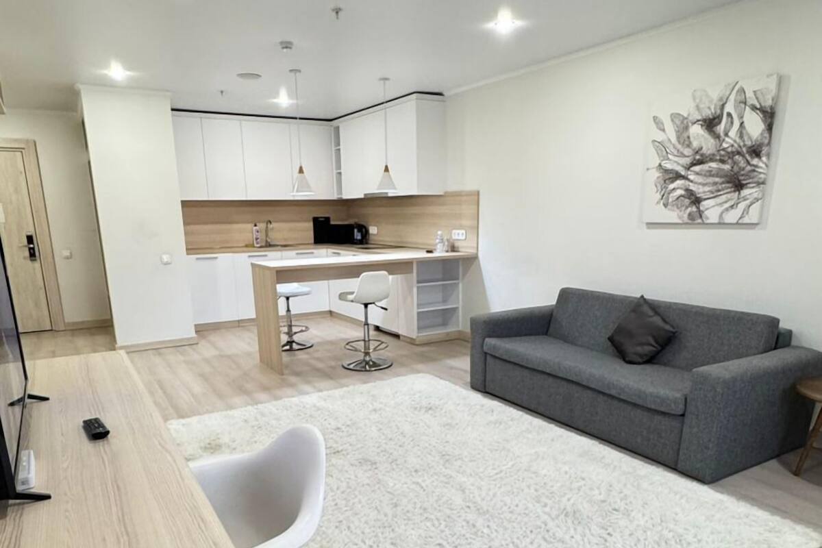 A modern apartment with a kitchen, dining area, and living room.