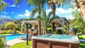 A hot tub in a backyard with a pool, lounge chairs, and a pergola. - Mirsini Villa Private Pool & Jacuzzi (Georgioupoli)