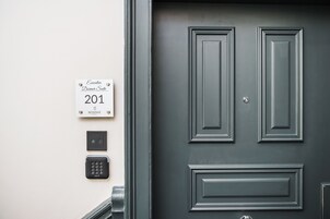 A dark grey door with a sign above it indicating "Executive Dormer Suite 201" and a room number "BONNIE 101".