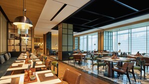 A modern dining area with long tables, chairs, and pendant lighting. - Four Points By Sheraton Chongqing North Railway Station (Chongqing)