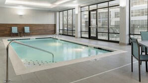 An indoor swimming pool with clear water, surrounded by a tiled floor and a wooden wall. - Fairfield By Marriott Inn & Suites Cincinnati Oakley (Cincinnati)