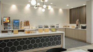A modern kitchen area with a white countertop, a hexagonal patterned backsplash, and a hanging light fixture. - Fairfield By Marriott Inn & Suites Cincinnati Oakley (Cincinnati)