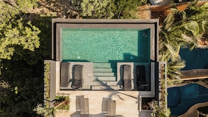 Eine Vogelperspektive auf einen modernen Poolbereich mit zwei Liegestühlen und einem kleinen Pool.