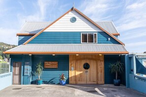 A two-story building with a blue exterior and a wooden front door. There is a sign above the door that reads "The Boathouse."