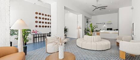 Eine moderne Hotelhalle mit einem geometrisch gemusterten Boden, einer Rezeption und gemütlichen Sitzbereichen.