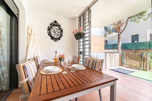 Enjoy meals in an outdoor setting with a table for two, striped cushions, and a potted plant.