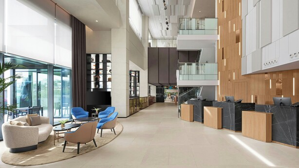Eine geräumige Lobby mit Empfangsschalter, Sitzgelegenheiten und einer Treppe zu den oberen Etagen.