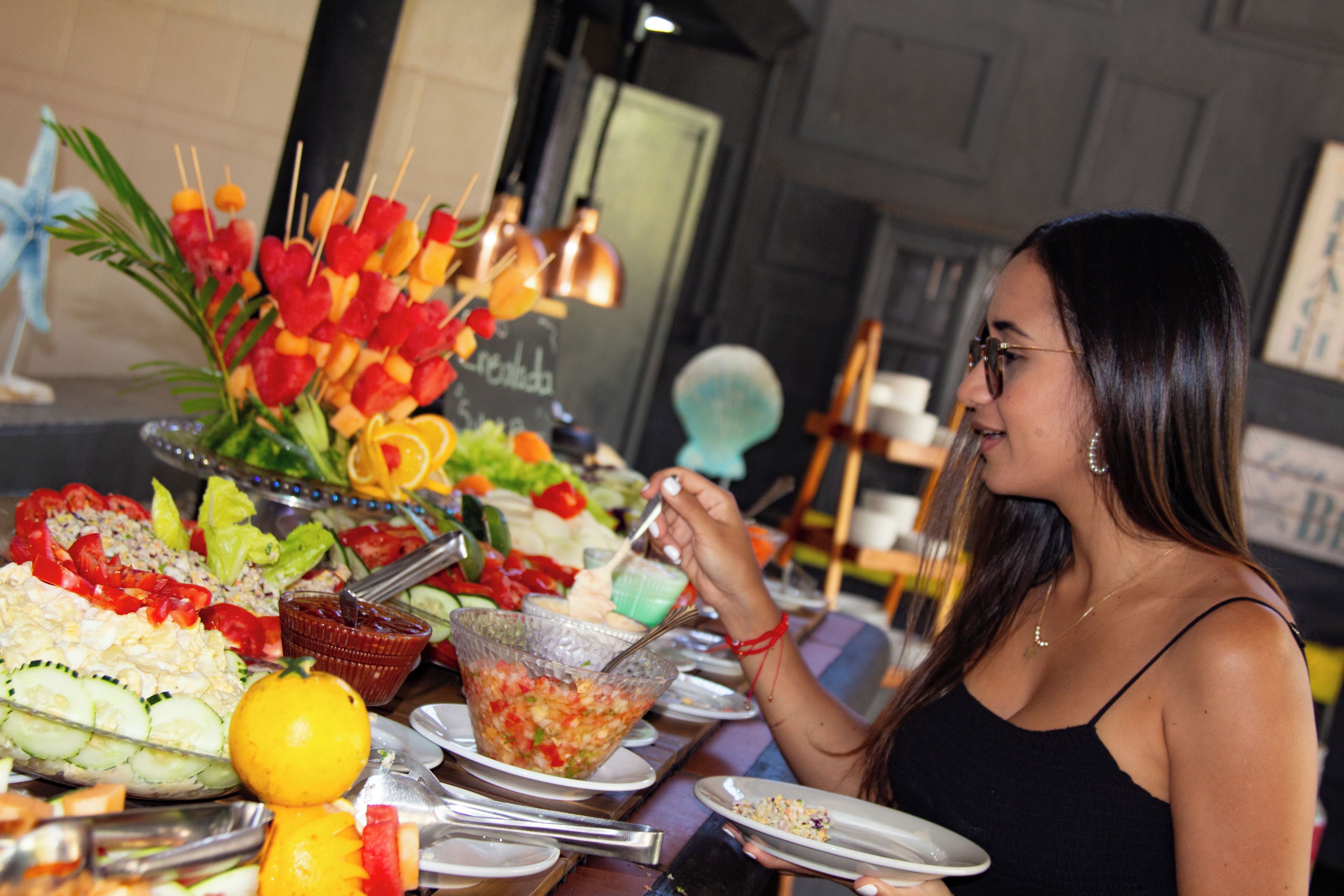 A dining table with various food items and a person eating.