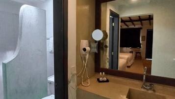 Un bagno con il water, un lavandino e uno specchio.
