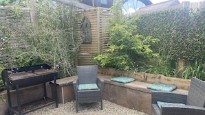 An outdoor patio with a grill, wicker chairs, a fire pit, and a wooden fence. - Stunning Coastal Retreat -mins From Harbour/beach (St Austell)