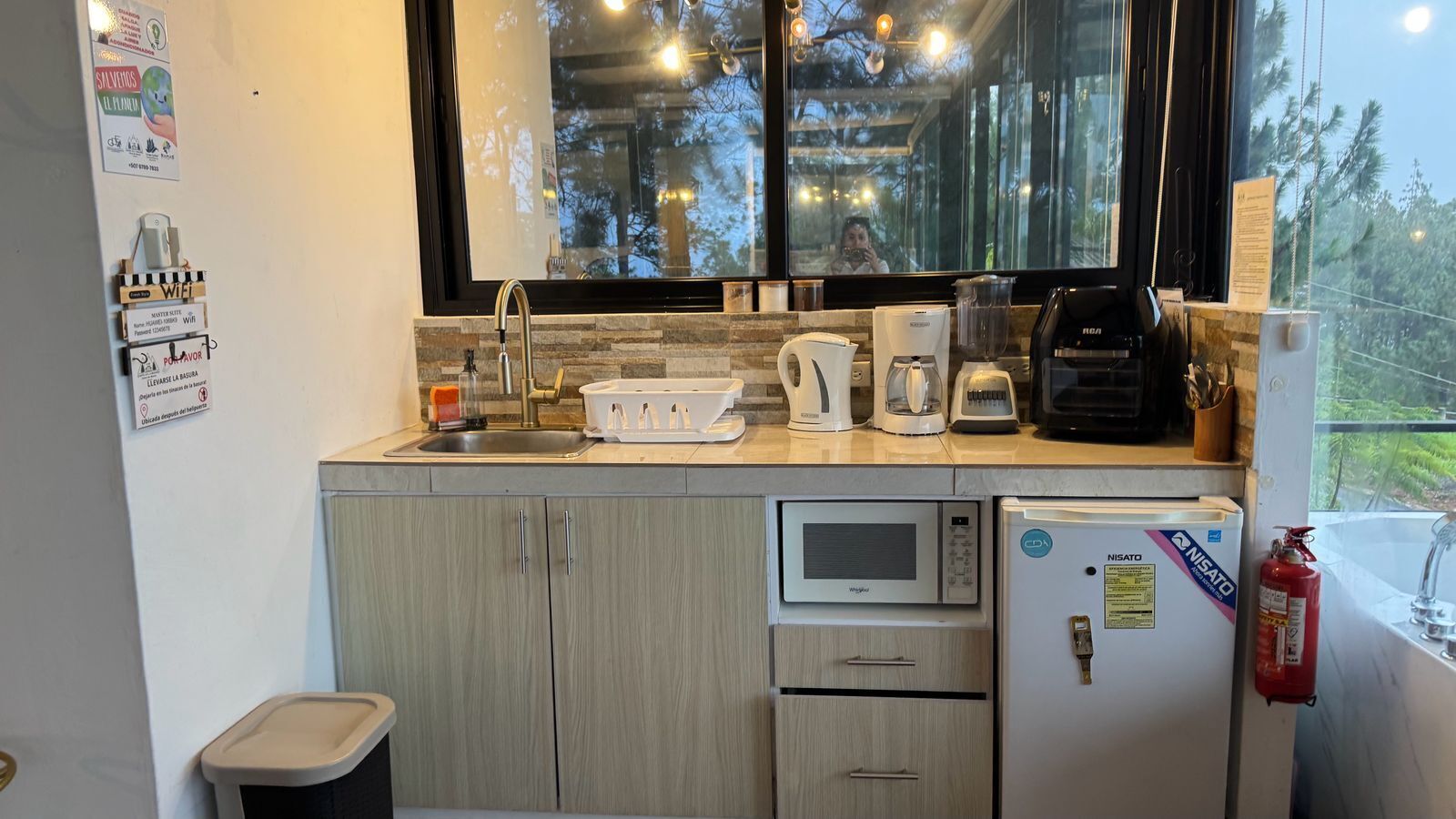 A compact kitchen with a sink, a microwave, a coffee maker, and a refrigerator.