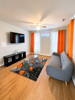A living room with a flat-screen TV, a sofa, a coffee table, and a patterned rug. - Private Villa 3-Bed|  7 min from Downtown (Raleigh)