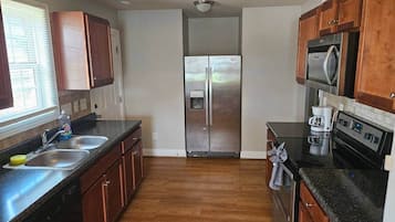 A kitchen with a stainless steel refrigerator, a microwave, and a coffee maker.