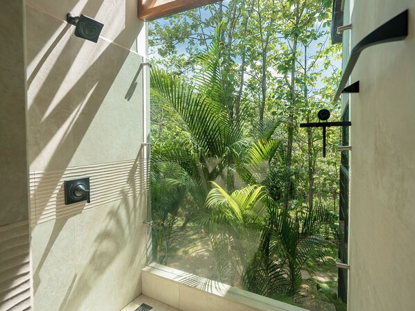 Ein Badezimmer mit Fenster, Handtuchhalter und Duschbedieneinheit.