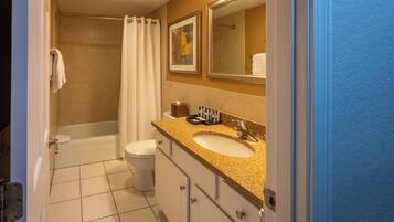 A bathroom with a bathtub, toilet, sink, and a mirror.