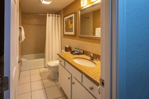 Un baño con bañera, inodoro, lavabo y espejo.