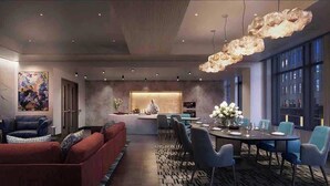 A modern dining area with a central island, blue chairs, and a chandelier. - Luxury Apartment w King Bed, Shared Pool & Rooftop (Cambridge)