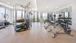 A gym with cardio equipment, weight machines, and free weights. - Upscale 1BR MIT Harvard WiFi Gym W D Parking! (Cambridge)