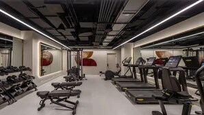 A modern gym with treadmills, weight machines, and dumbbells.