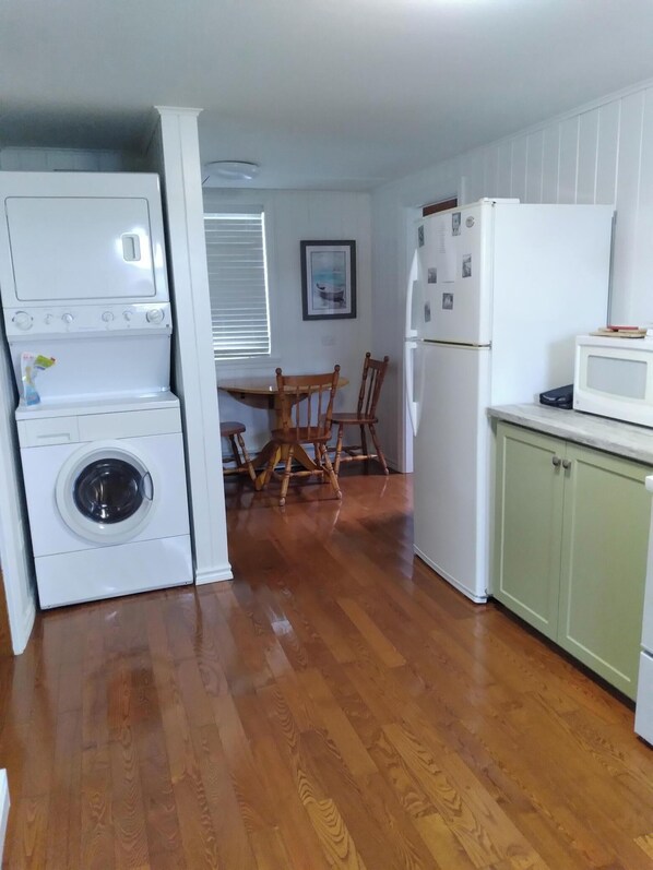 Cocina compacta con lavadora, microondas y refrigerador.