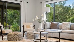 A modern living room with a sofa, armchair, ottoman, and coffee table. - Vineyard Haven: Pool, Hot Tub & Wine Country Charm (Kenwood)