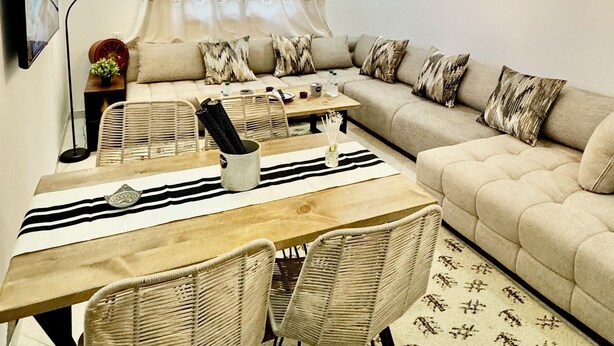 Un salon confortable avec un canapé, une table à manger et des chaises, un téléviseur et un ventilateur de plafond.
