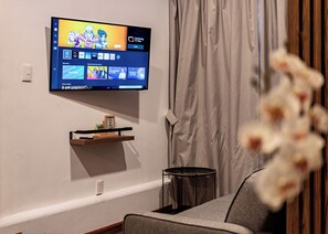 Apartamento Deluxe | Zona de estar | Televisión de pantalla plana de 42 pulgadas con canales digitales