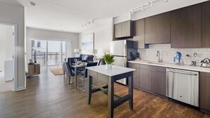 A modern kitchen with dark wooden cabinets, a stainless steel refrigerator, and a white countertop. - Walk to U Street Metro |  A block from Whole foods & Shops (Reston)