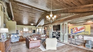 Un intérieur rustique avec un plafond en bois, un coin repas et une cuisine.