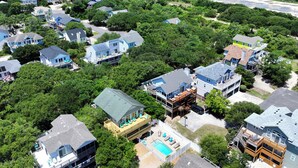 An aerial view of a residential area with houses, a swimming pool, and a dock. - Oceanside, Private Pool, Hot Tub, OS4N, Kaerolla Dawn (Corolla)