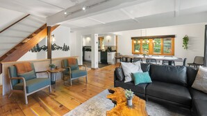 A spacious living area with a staircase, a dining area, and a kitchen.
