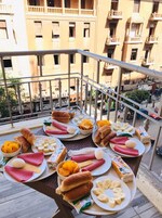 A balcony with a variety of food items including bread, eggs, and bananas.