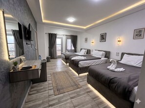 A modern hotel room with two beds, a desk, a TV, and a balcony view. - Park Plaza hotel (Cairo)