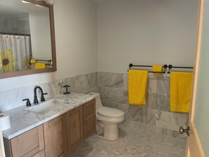 Een douche,  milieuvriendelijk toiletgerief, handdoeken, zeep