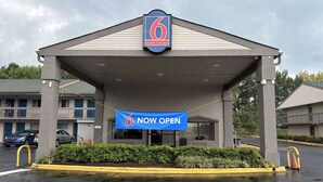 A 6 Motel & Studio building with a 'NOW OPEN' banner.