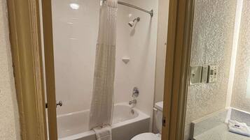 A bathroom with a bathtub, toilet, and a shower curtain.