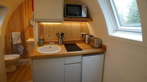 A compact kitchen with a microwave, toaster, sink, and dishwasher.