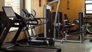 A gym with treadmills, weight machines, and a large window.