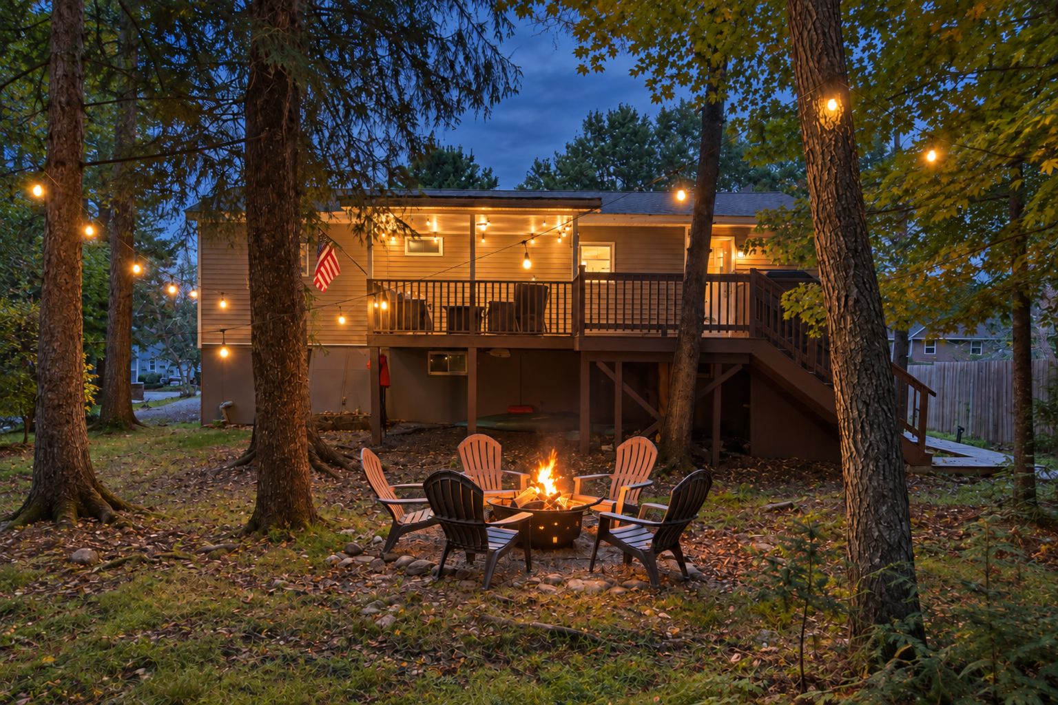 A house with a deck, outdoor seating, and a fire pit.