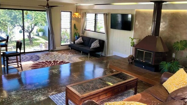 Un salon spacieux avec une grande table basse en verre, un canapé et une cheminée.