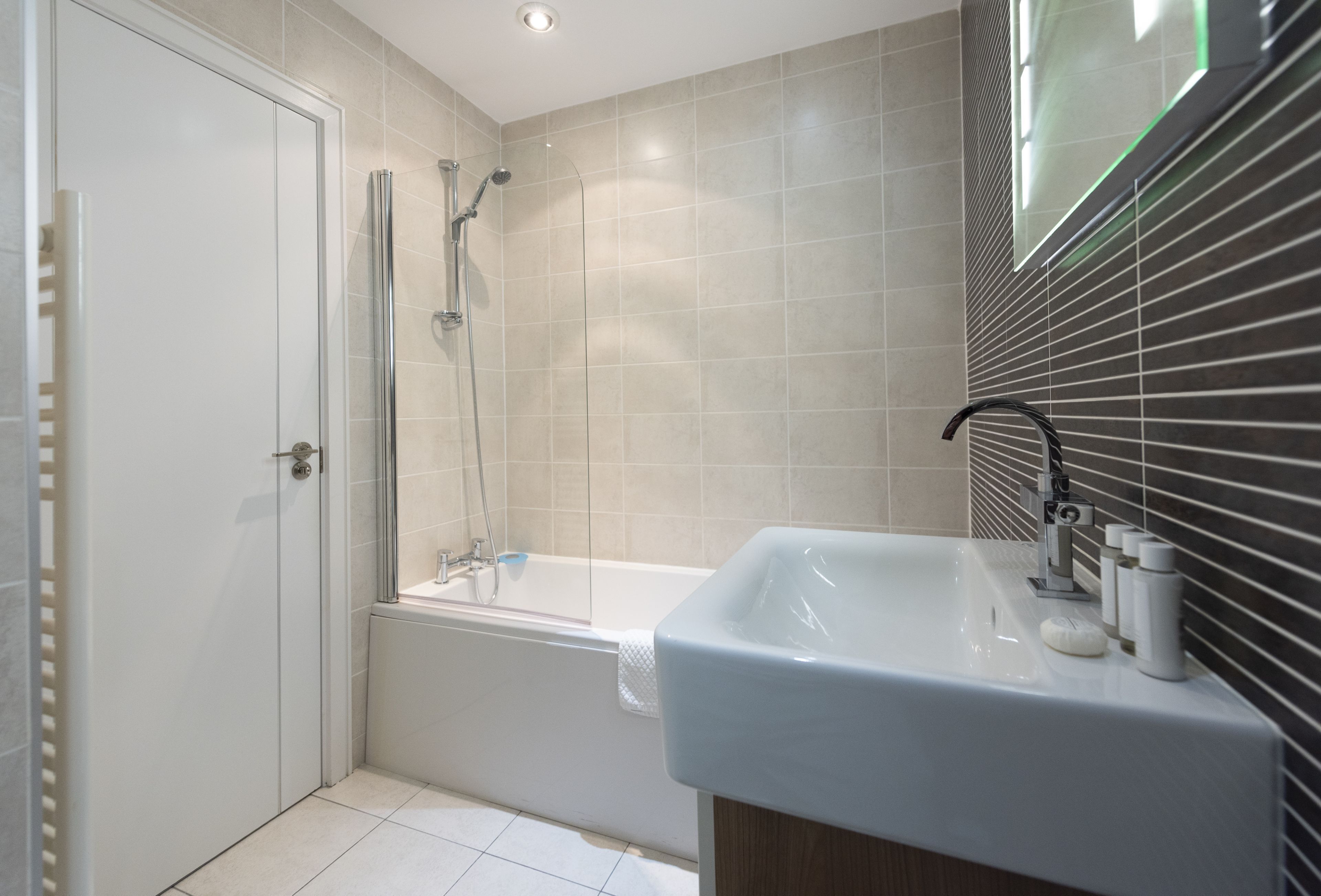 Un baño moderno con ducha, bañera y lavamanos.