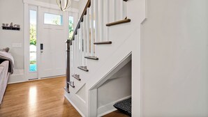 A staircase with wooden handrails and a white wall.