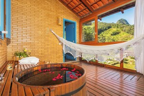 A wooden deck with a hot tub, a hammock, and a view of a mountainous landscape. - Parador Lumiar Hotel & Spa (Nova Friburgo)