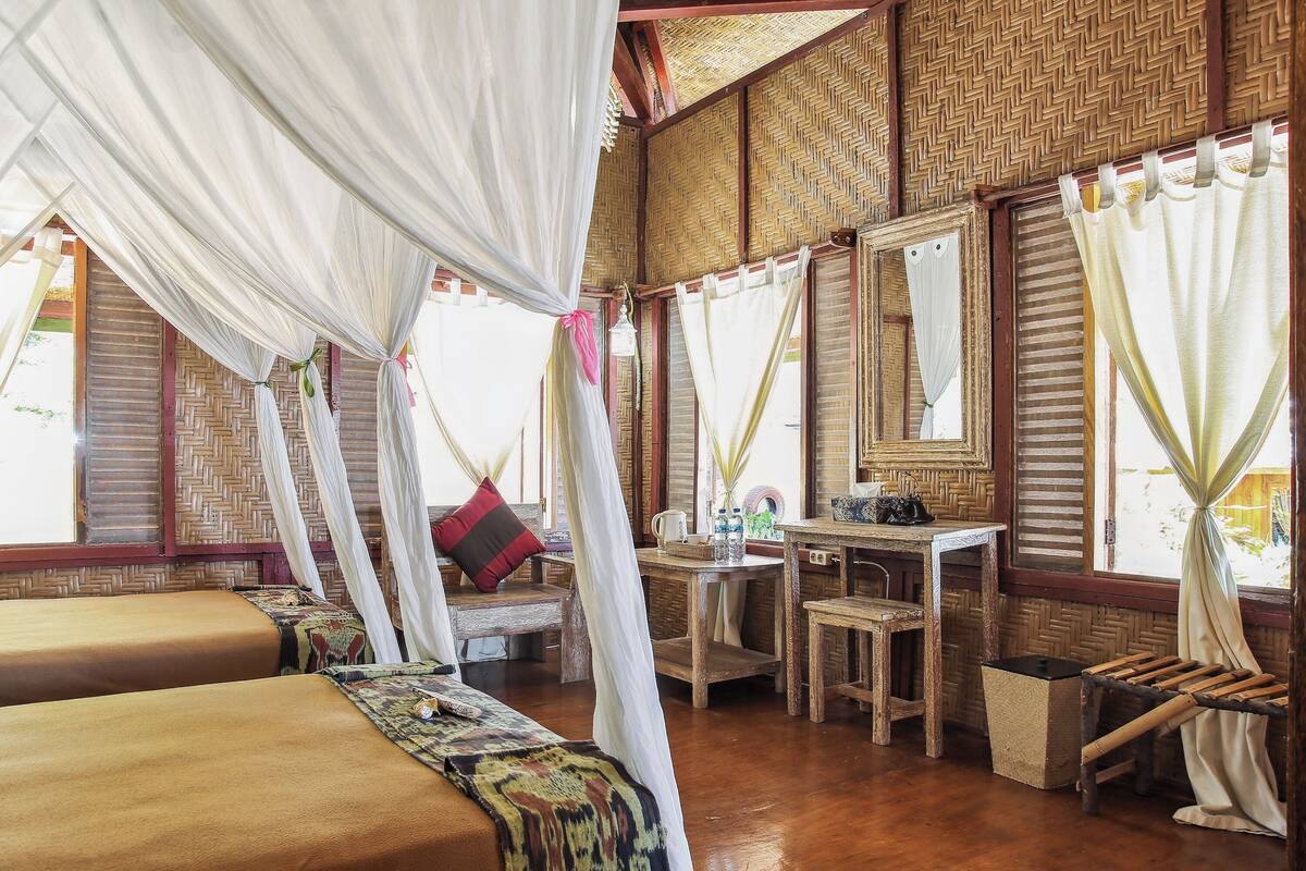 Ein Zimmer mit zwei Betten, einem Schreibtisch und einem Spiegel.